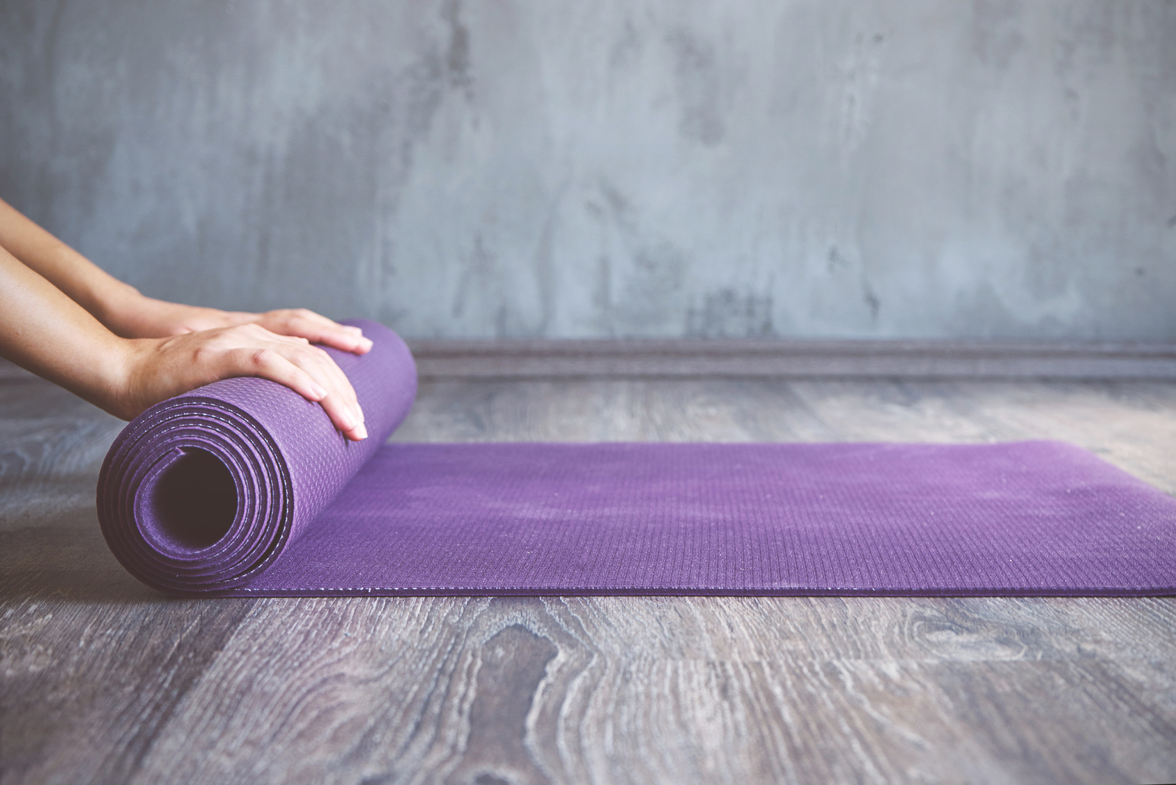 Woman rolling her mat after a yoga class